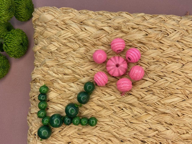 Handmade natural raffia clutch purse bag with pink and green beads in flower design, created using a complete beginners raffia course