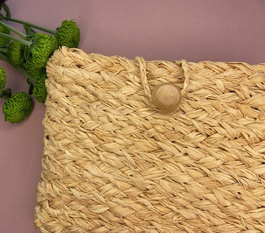 Hanmade natural raffia clutch purse bag with a loop and wooden button closure, created using a complete beginners raffia course