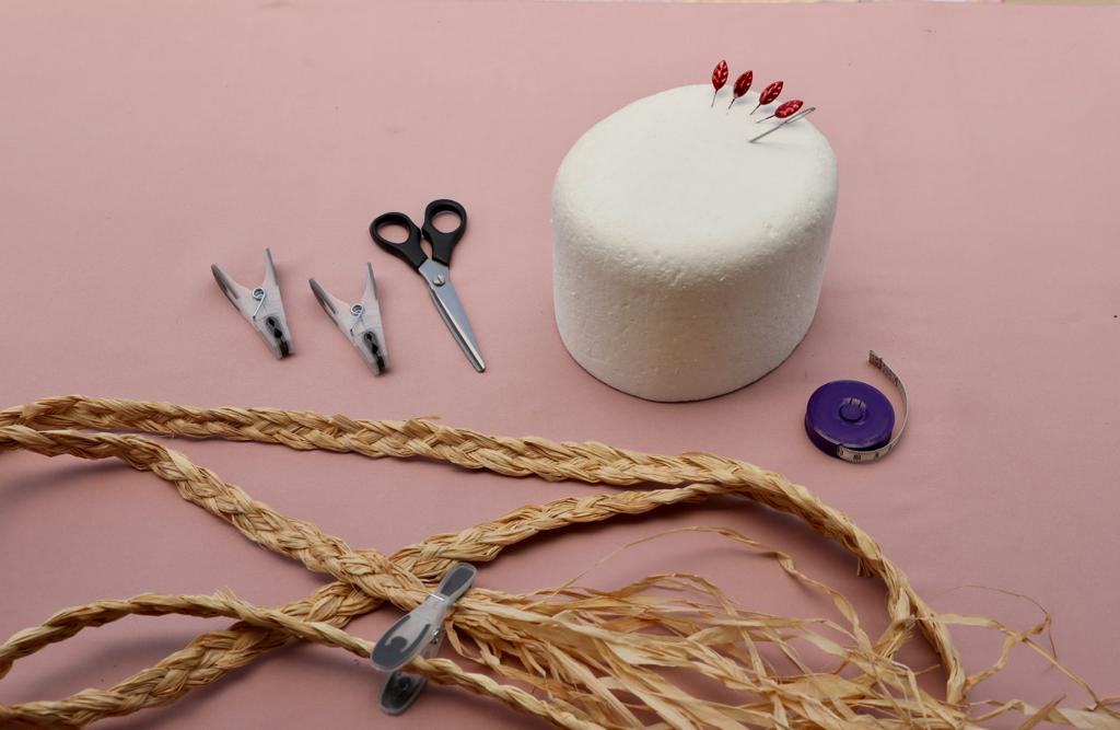 Raffia craft equipment for raffia hat making, scissors, pegs, plystyrene sized hat block, pinks, needle, raffia plait and tape measure