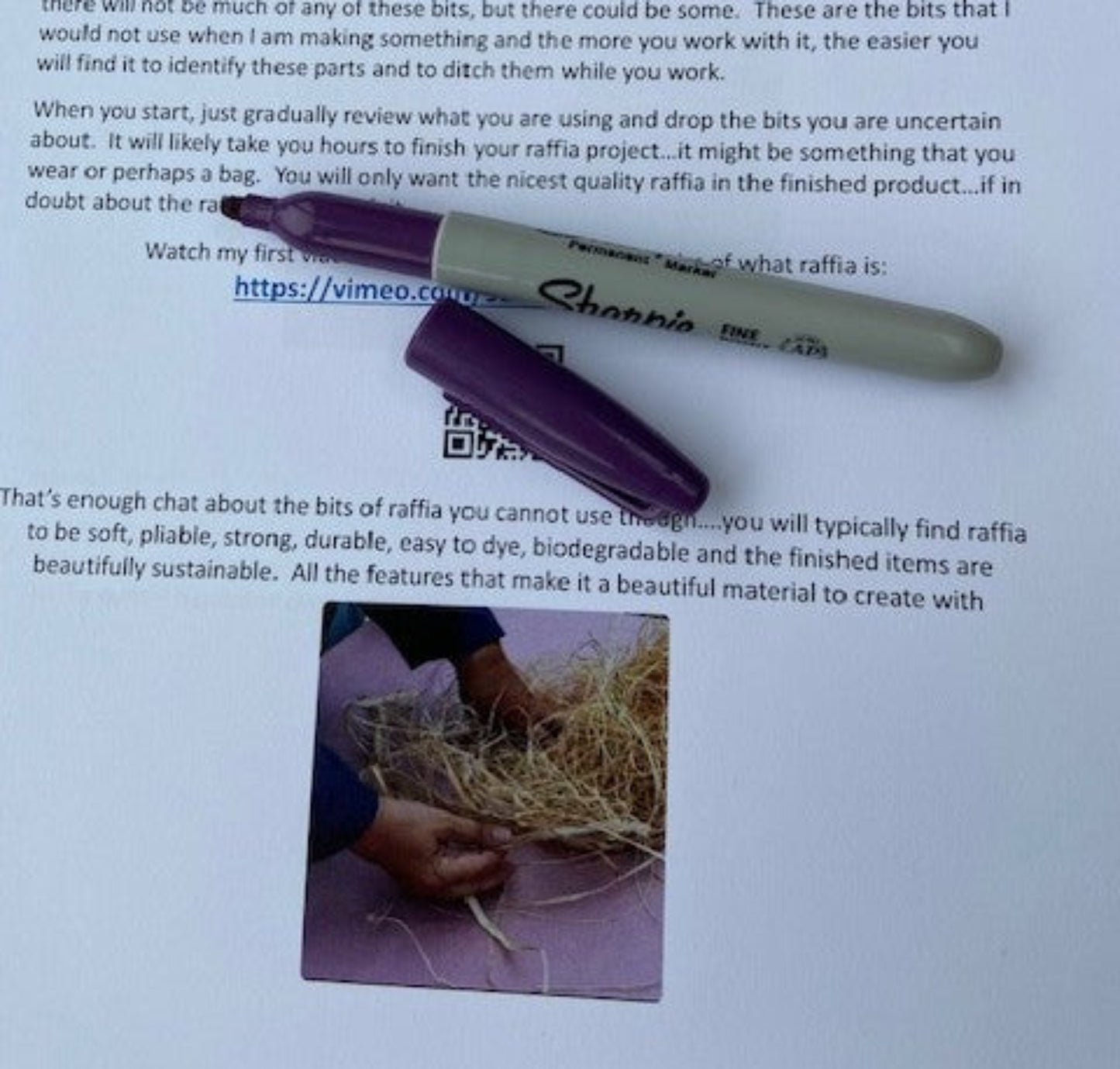 Example page from course workbook, pen covering the QR code and vimeo link information
