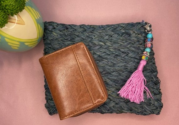 Handmade raffia dyed blue clutch purse bag with a zip finish and a beaded tassel attached, created using a complete beginners raffia course