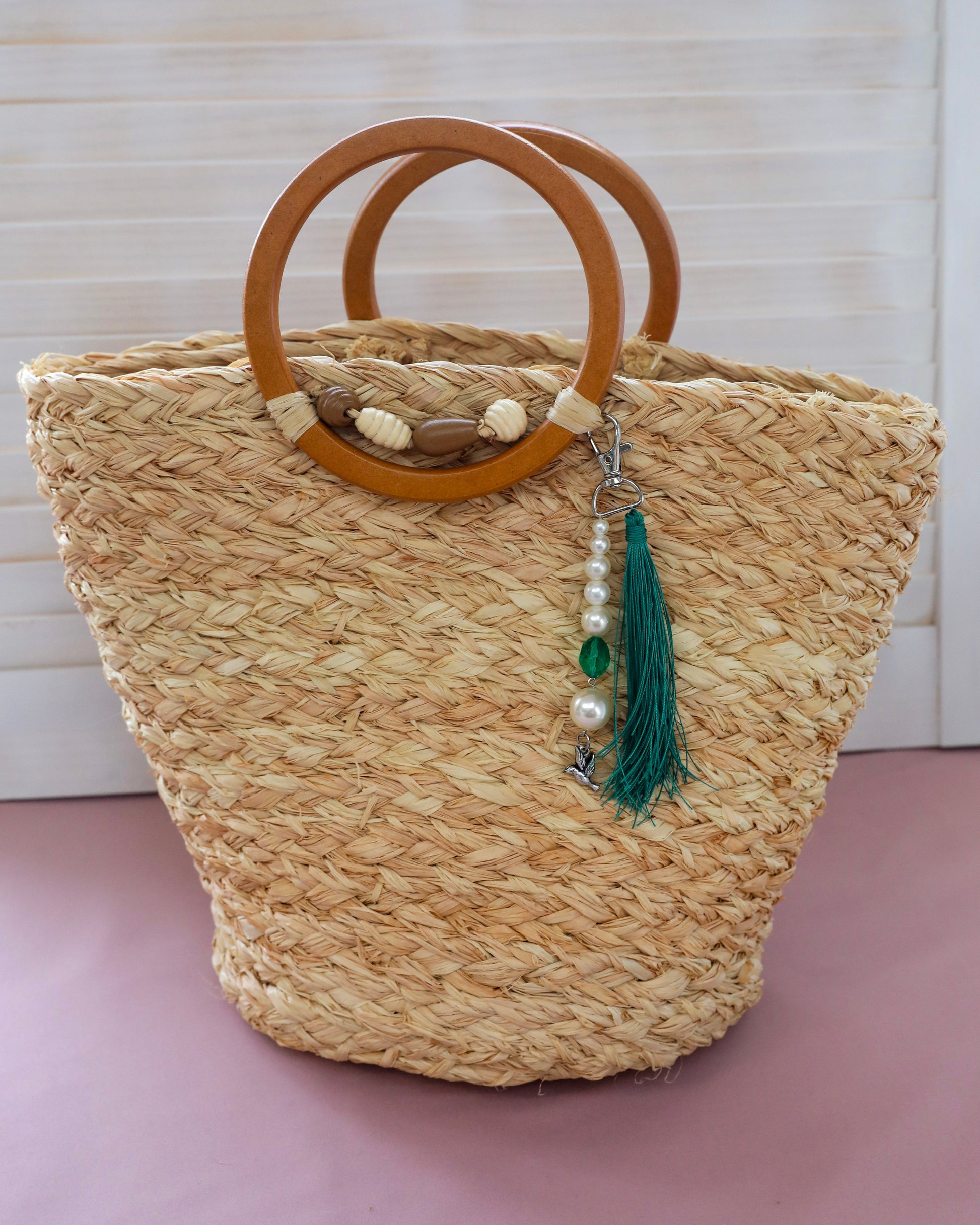 Raffia bucket bag with wooden handles, bead and green tassel decoration
